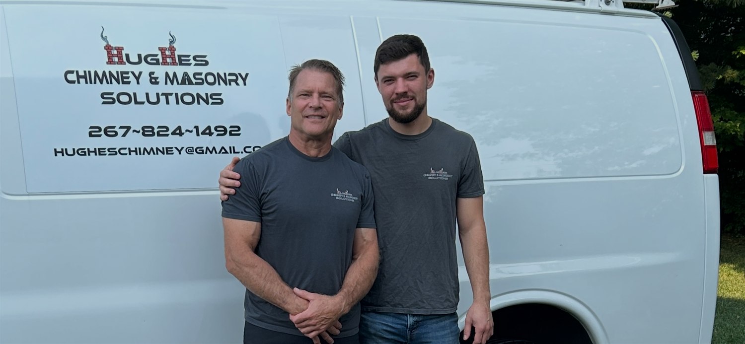 Darryl and his son Jake, the father-and-son owners of Hughes Chimney & Masonry Solutions, in front of the company van